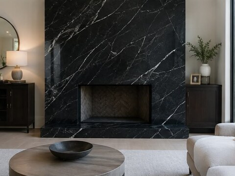 Floor-to-ceiling black marble slab fireplace wall with bold white veining