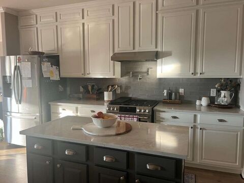 White quartz countertops with contrasting dark island cabinetry