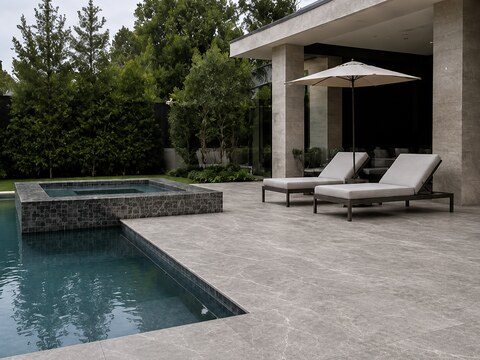 Pool deck with large-format stone pavers and a raised mosaic-tiled spa